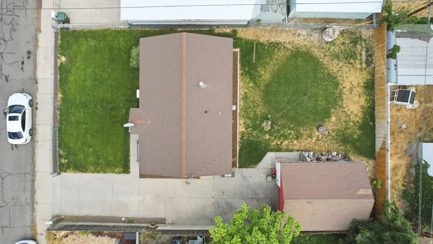 Property featuring a brown shingle roof, concrete driveway, and a detached red shed with a brown shingle roof