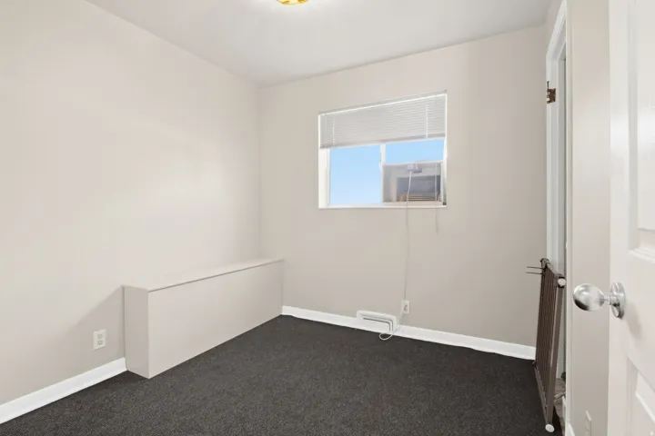 Neutral-toned walls complement dark gray carpeting