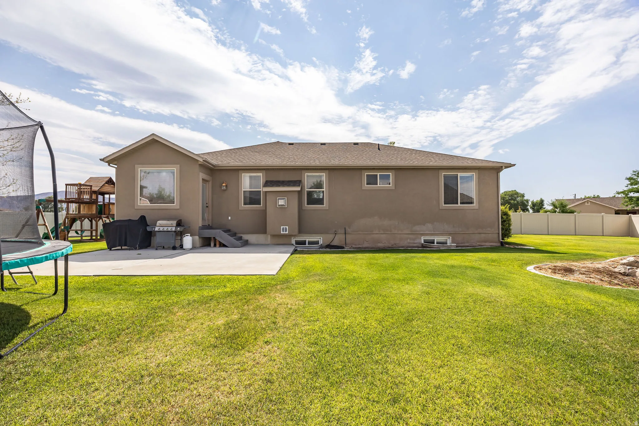 Expansive green lawn with a concrete patio