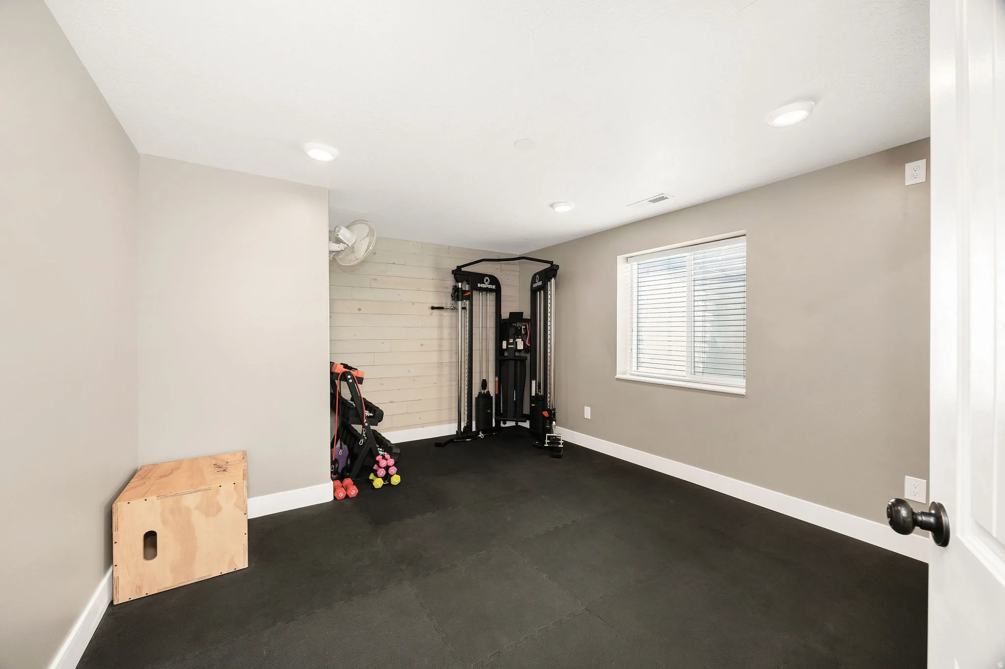 Room with cushioned flooring, recessed lighting, and a window with blinds