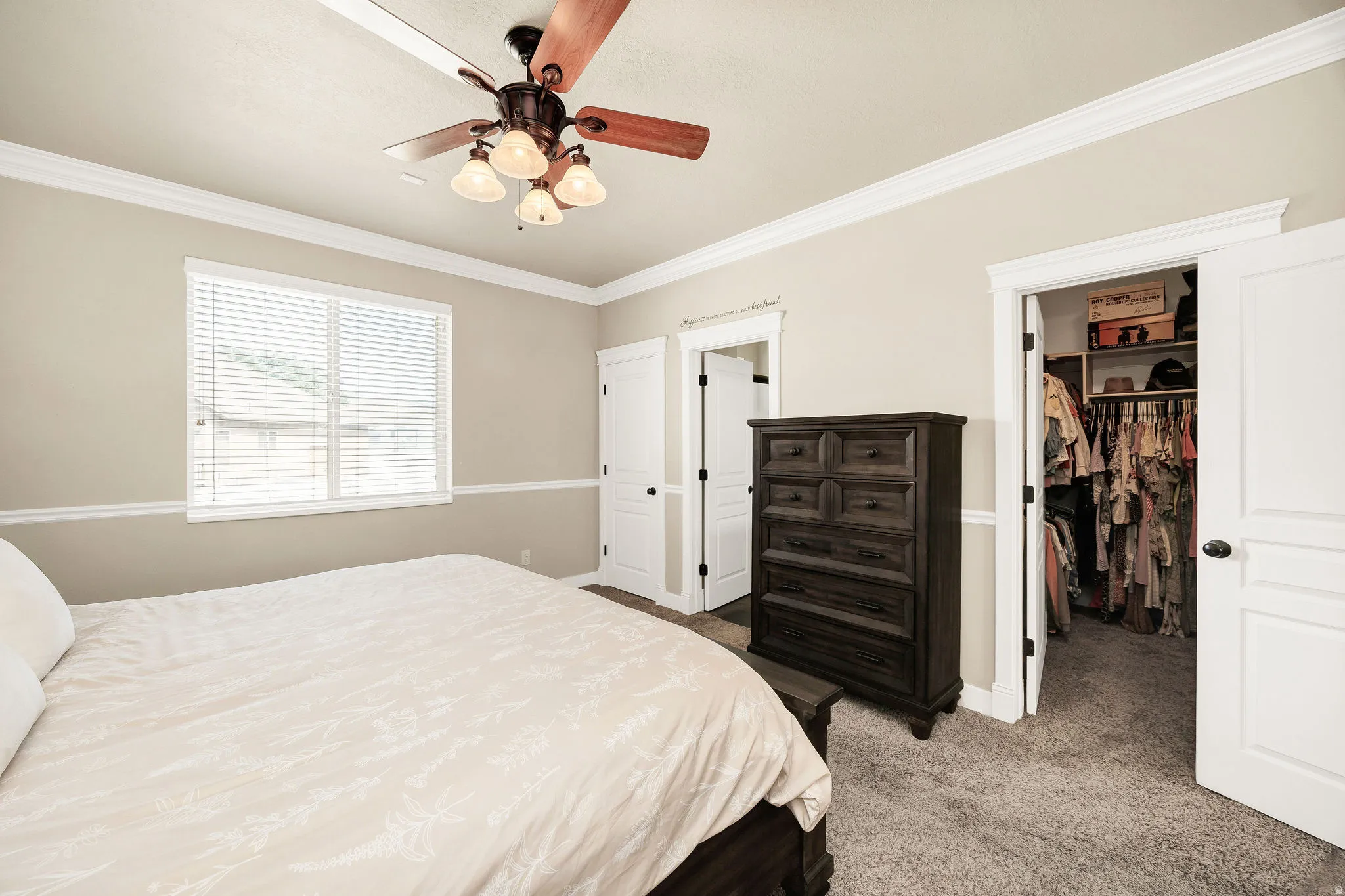 Bedroom featuring crown molding, a ceiling fan with integrated lighting, window blinds, and carpet flooring