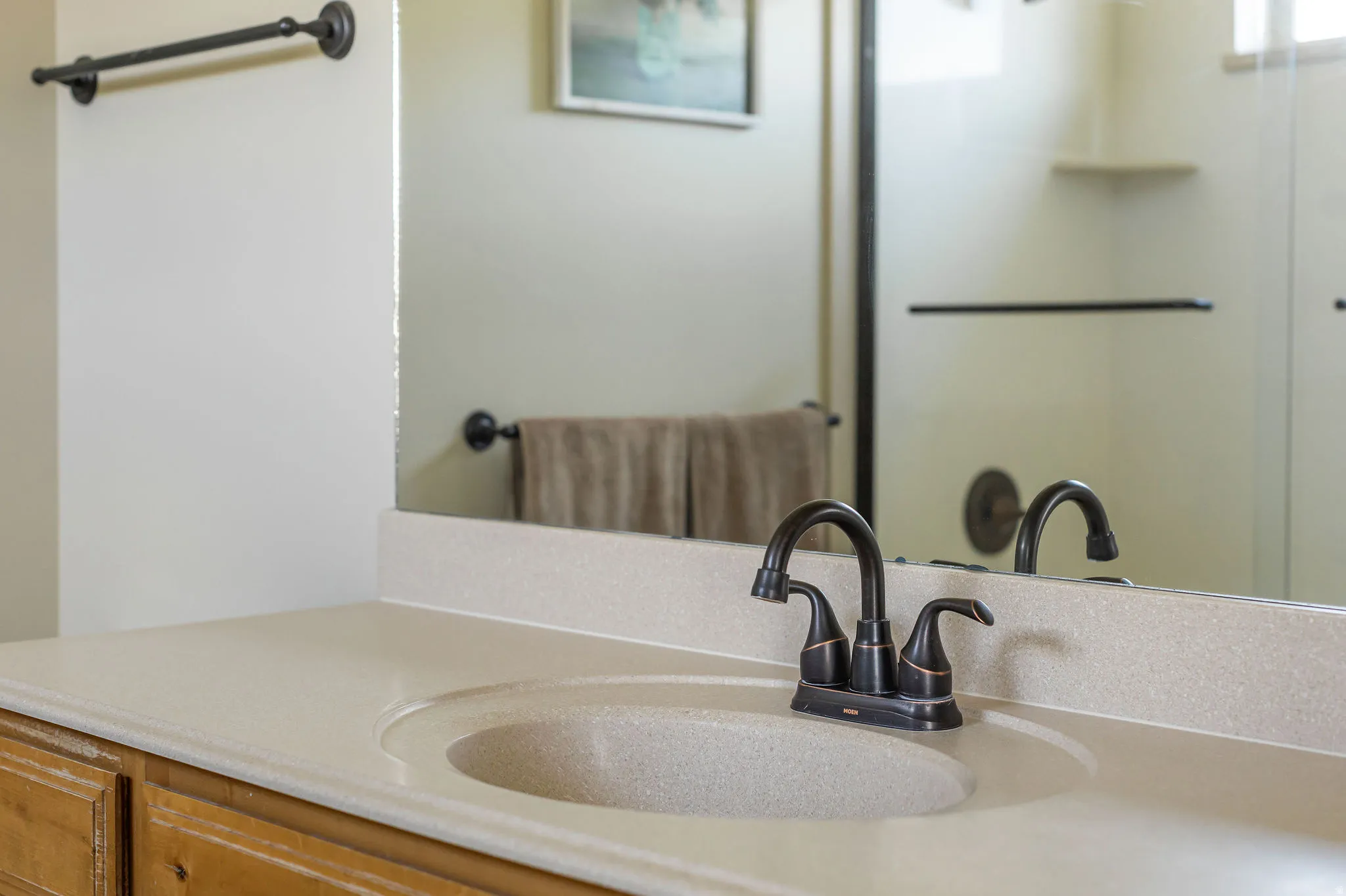 Bathroom vanity featuring an integrated sink, a solid surface countertop, and a dark bronze finish faucet