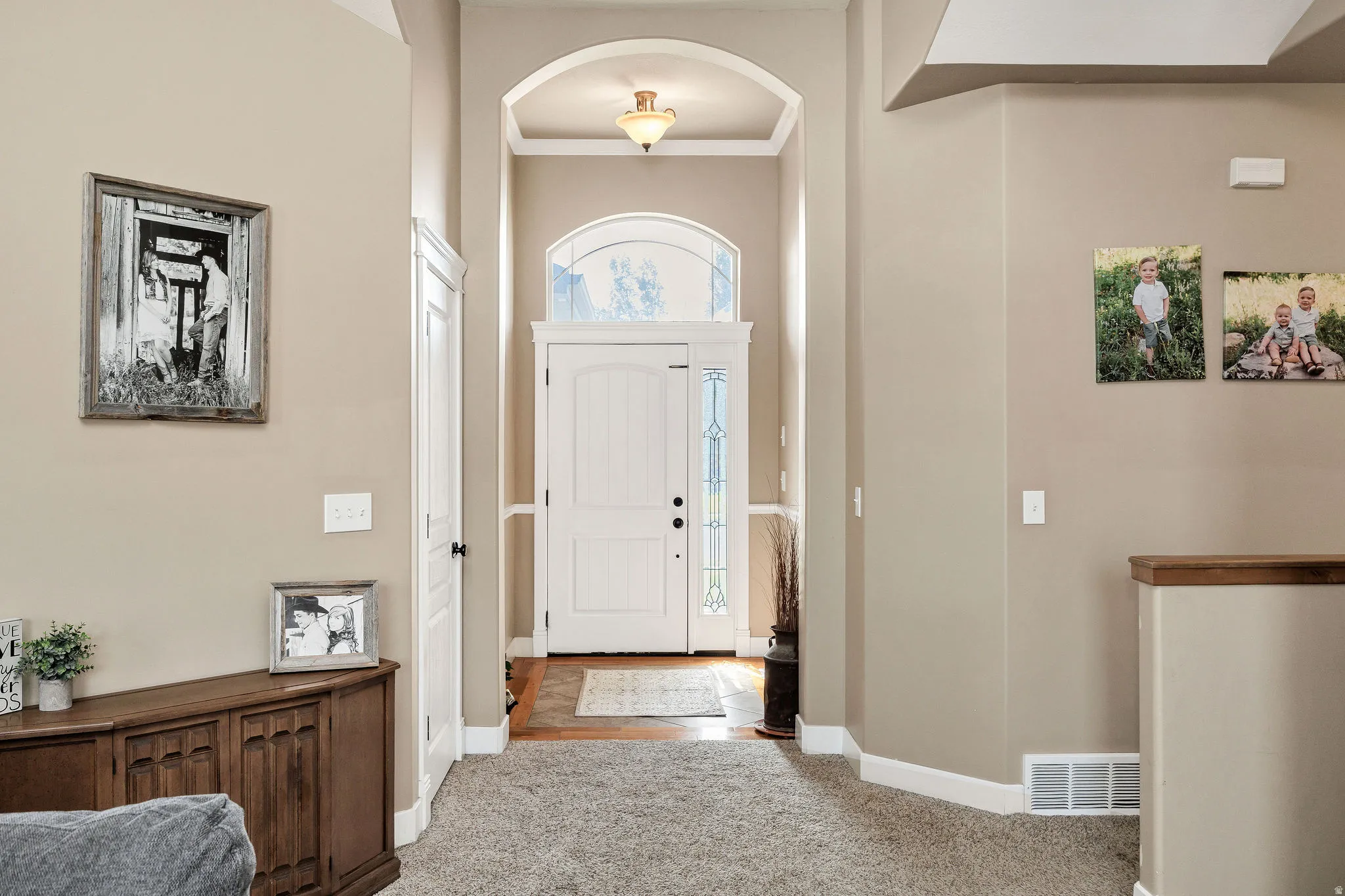 Grand entryway featuring an arched doorway, decorative transom window, and ornate sidelights