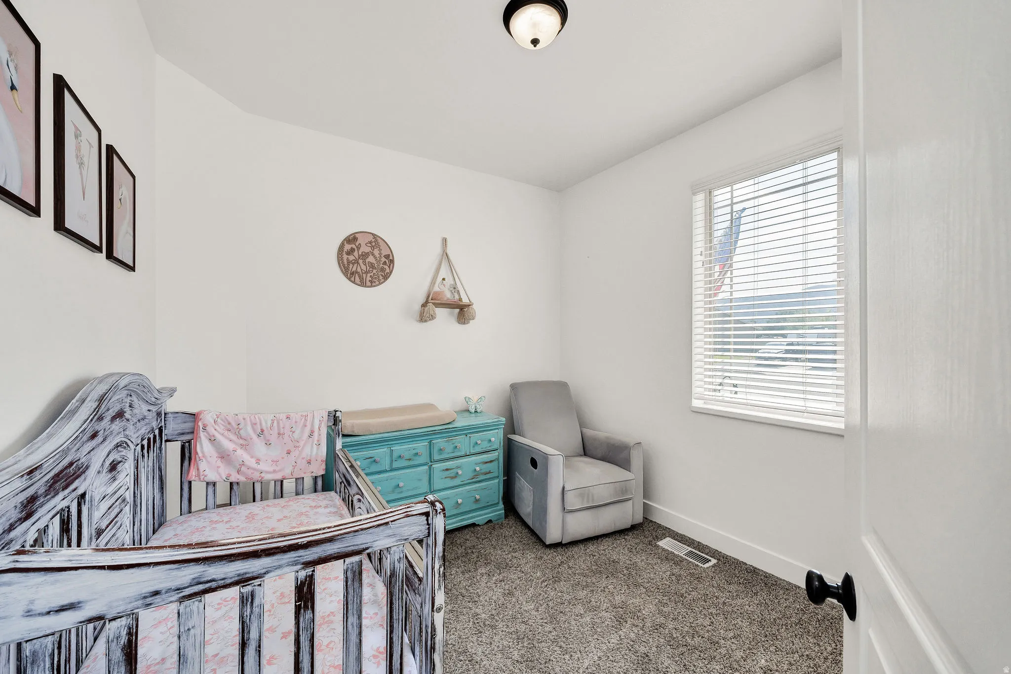 Room featuring light gray carpet, white walls, and a single window with horizontal blinds
