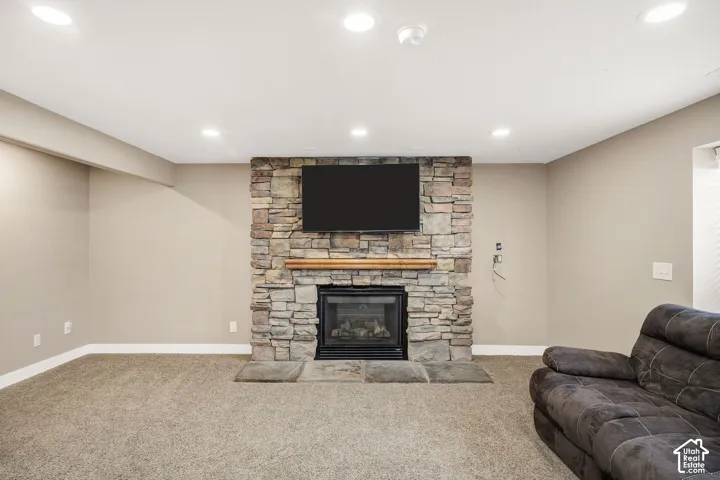 Stone-clad fireplace with a wood mantle, integrated hearth, and mounted display