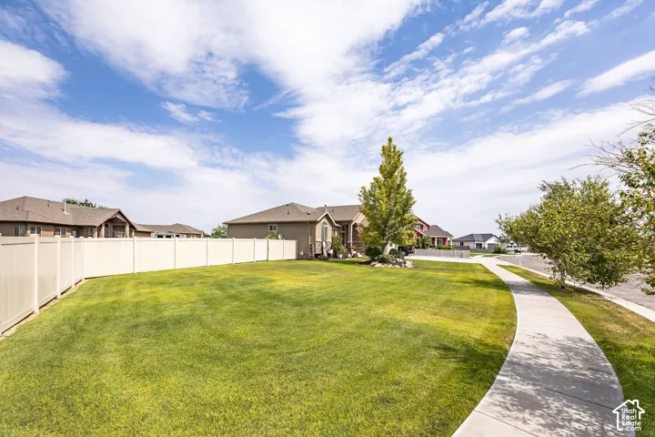 Expansive lawn area bordered by a light-toned privacy fence
