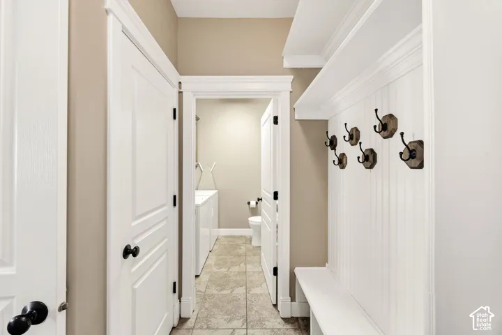 Entryway featuring a built-in bench with beadboard backing, storage cubbies, and six decorative coat hooks