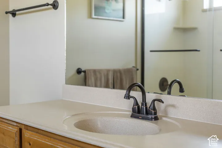 Bathroom vanity featuring an integrated sink, a solid surface countertop, and a dark bronze finish faucet