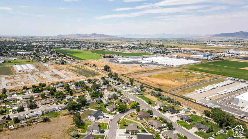 Expansive aerial view showcasing residential areas, agricultural fields, and commercial/industrial structures