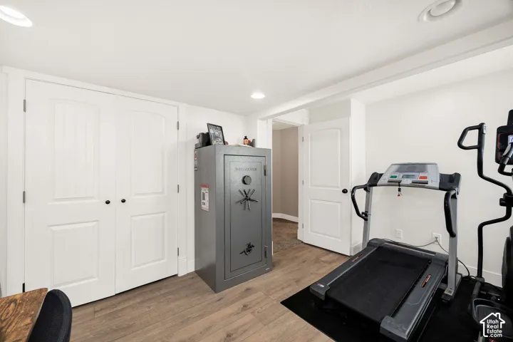 Room featuring wood-finish flooring, recessed lighting, and white walls
