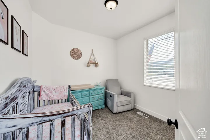 Room featuring light gray carpet, white walls, and a single window with horizontal blinds