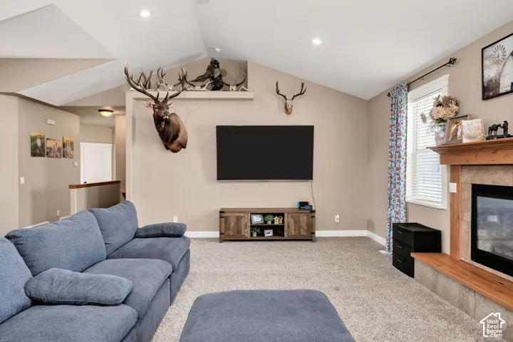 Spacious living area featuring vaulted ceilings, recessed lighting, and neutral wall tones