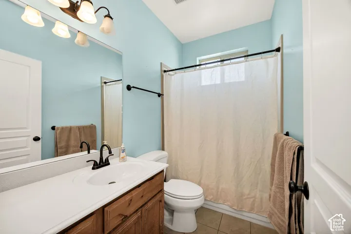 Bathroom featuring a wood-finish vanity with an integrated sink and a white countertop