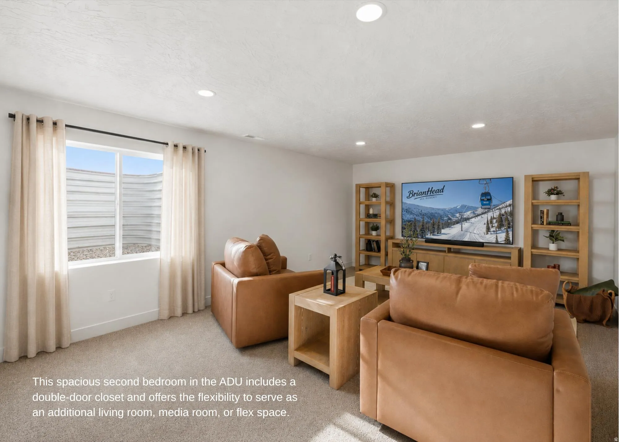 Spacious room featuring neutral carpeting, recessed lighting, and a large window with light-filtering curtains