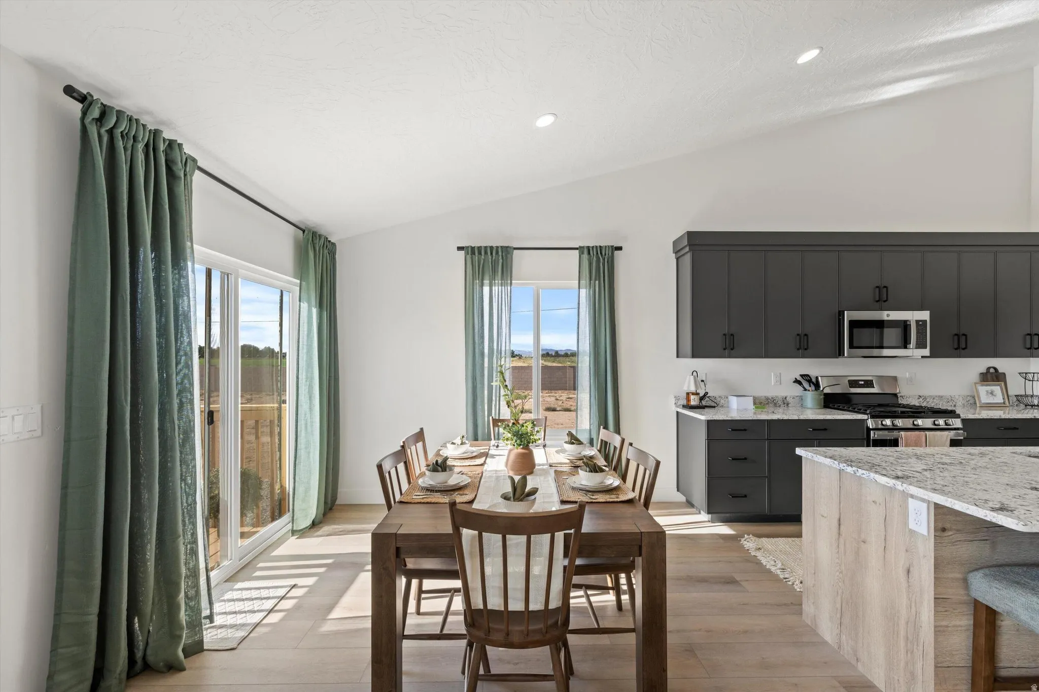Vaulted ceilings highlight this open-concept dining area and kitchen