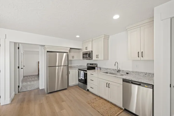 Contemporary kitchen featuring light wood-finish cabinetry and stainless steel appliances