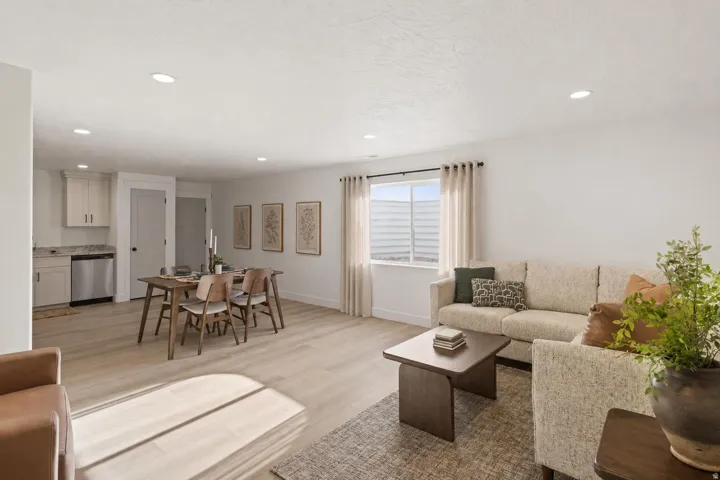 Open-concept living space featuring wood-finish flooring, recessed lighting, and a modern kitchen area with stainless steel appliances