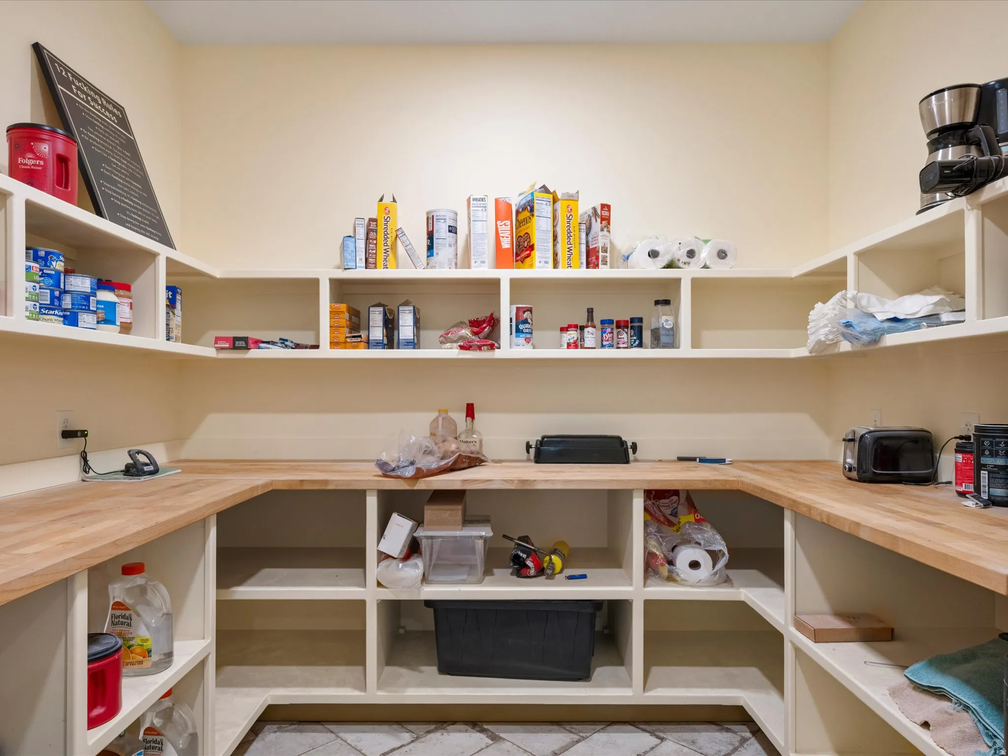 Custom-built pantry featuring extensive shelving, light wood-finish countertops, built-in lower cabinetry, and recessed lighting