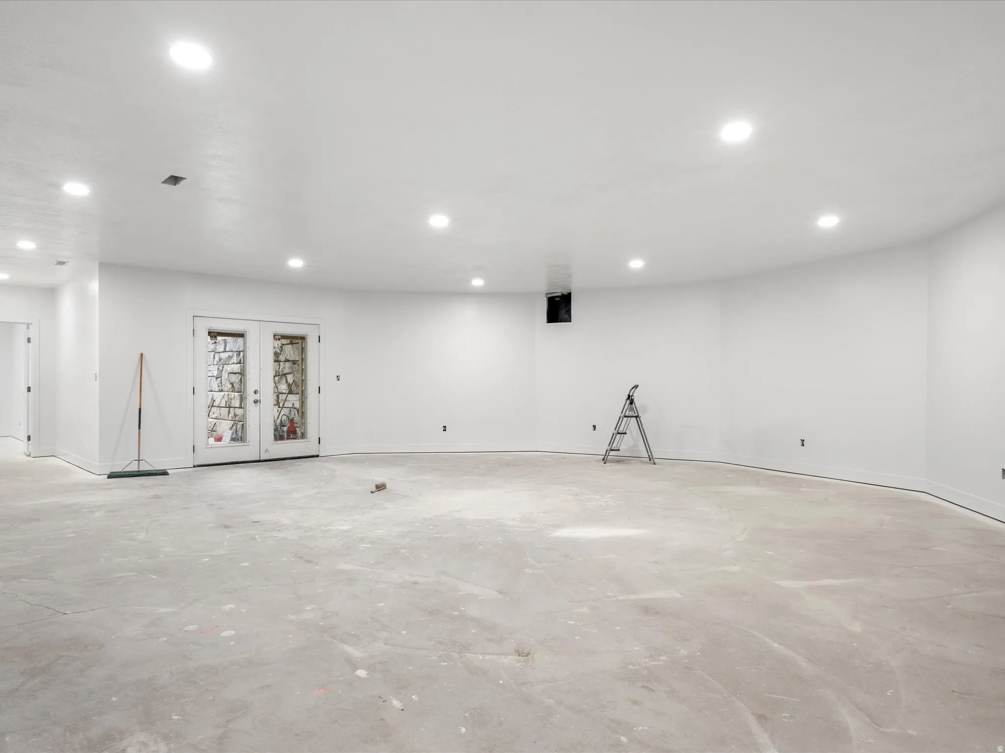 Spacious unfinished room with recessed lighting and concrete flooring