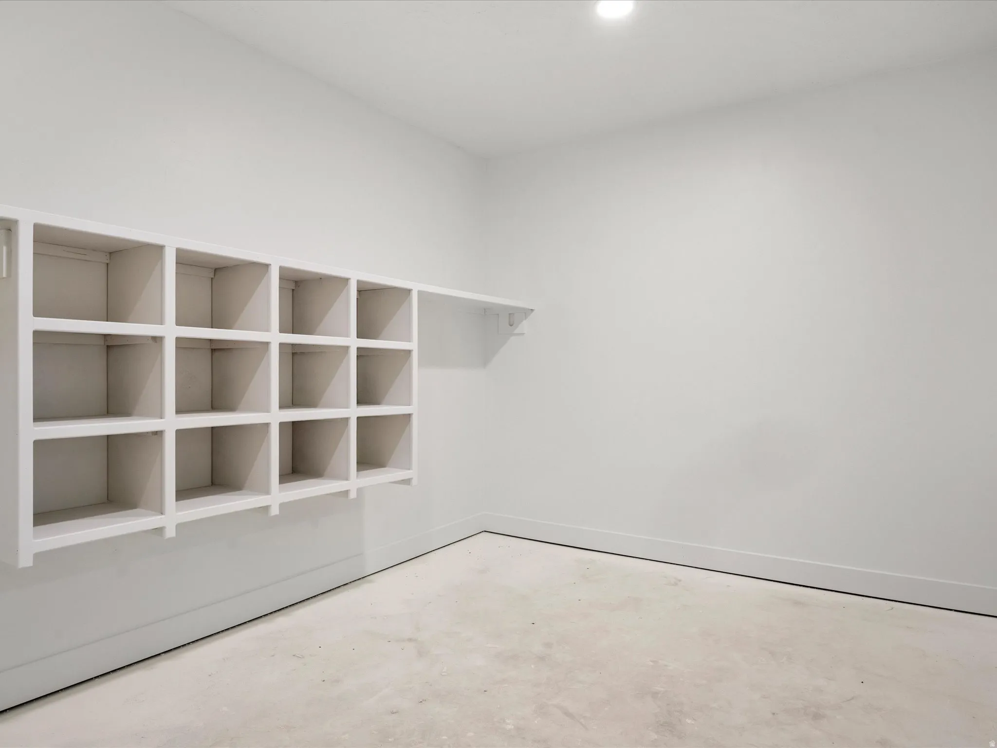 Built-in cubby storage with an integrated shelf, recessed ceiling lighting, light-toned walls, and baseboard molding