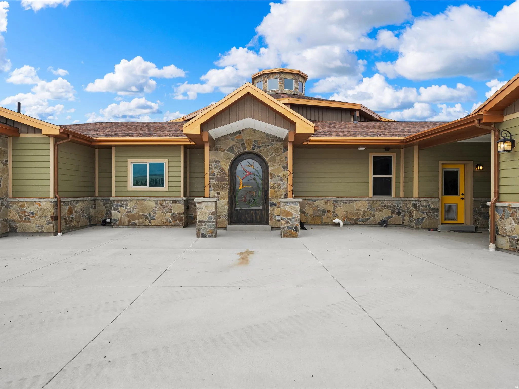 Stone veneer exterior with green siding and brown trim