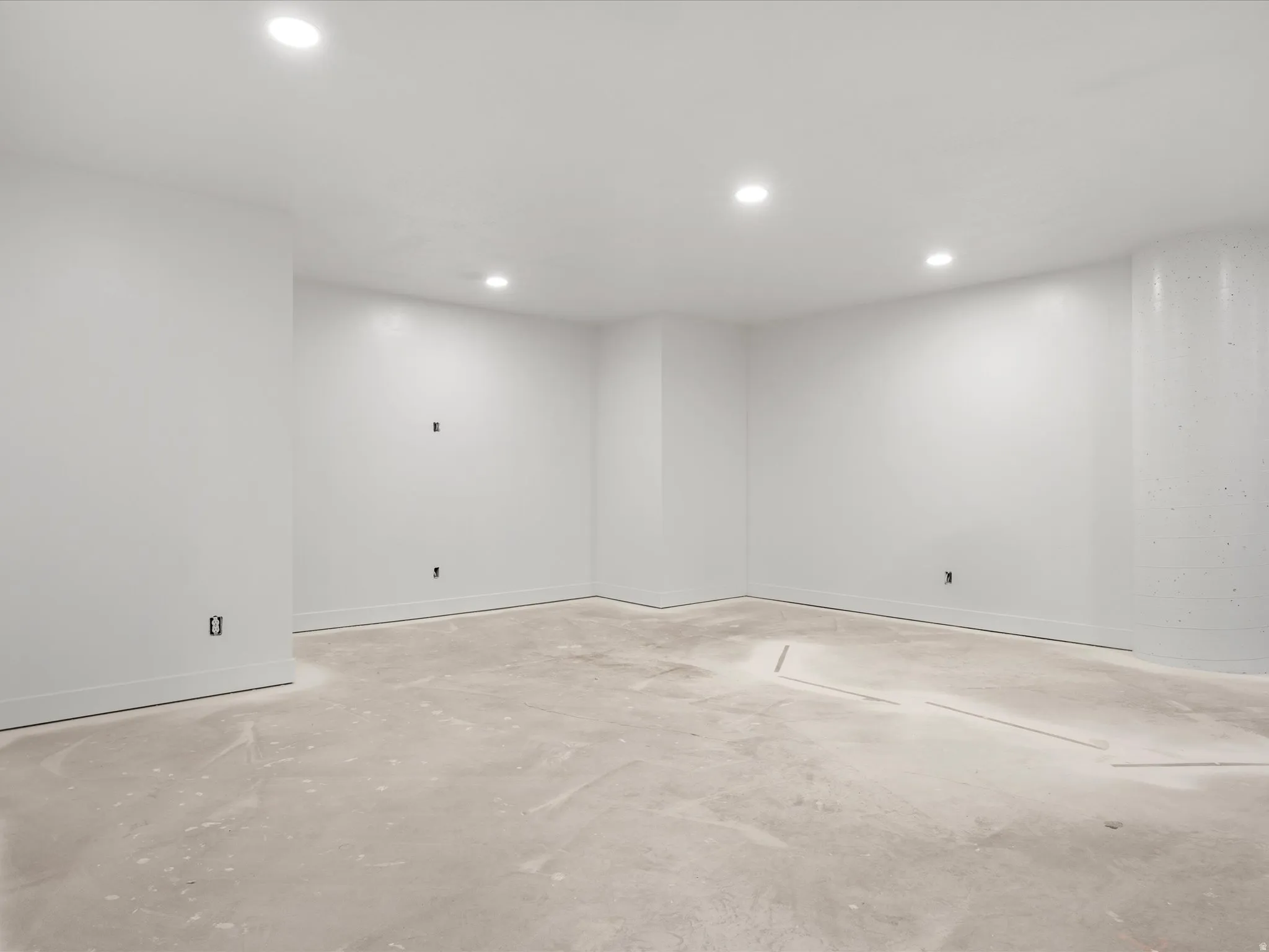 Unfinished interior space featuring white walls and a concrete floor
