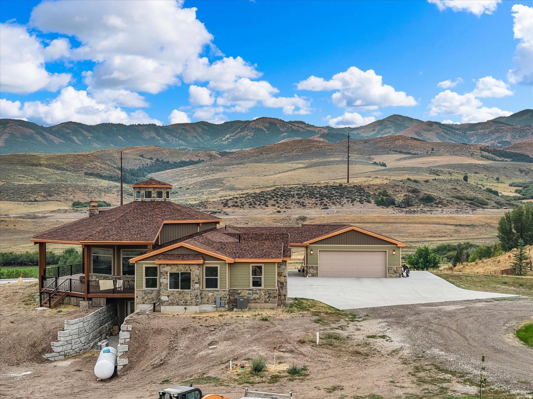 This property features a multi-level residence with a distinct cupola, an attached two-car garage, and a spacious concrete driveway