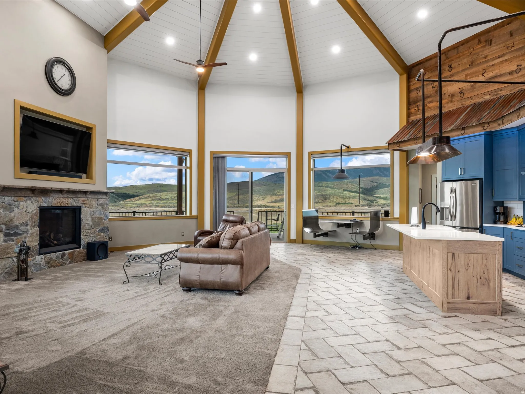 Vaulted ceiling with exposed wood beams, recessed lighting, and ceiling fans