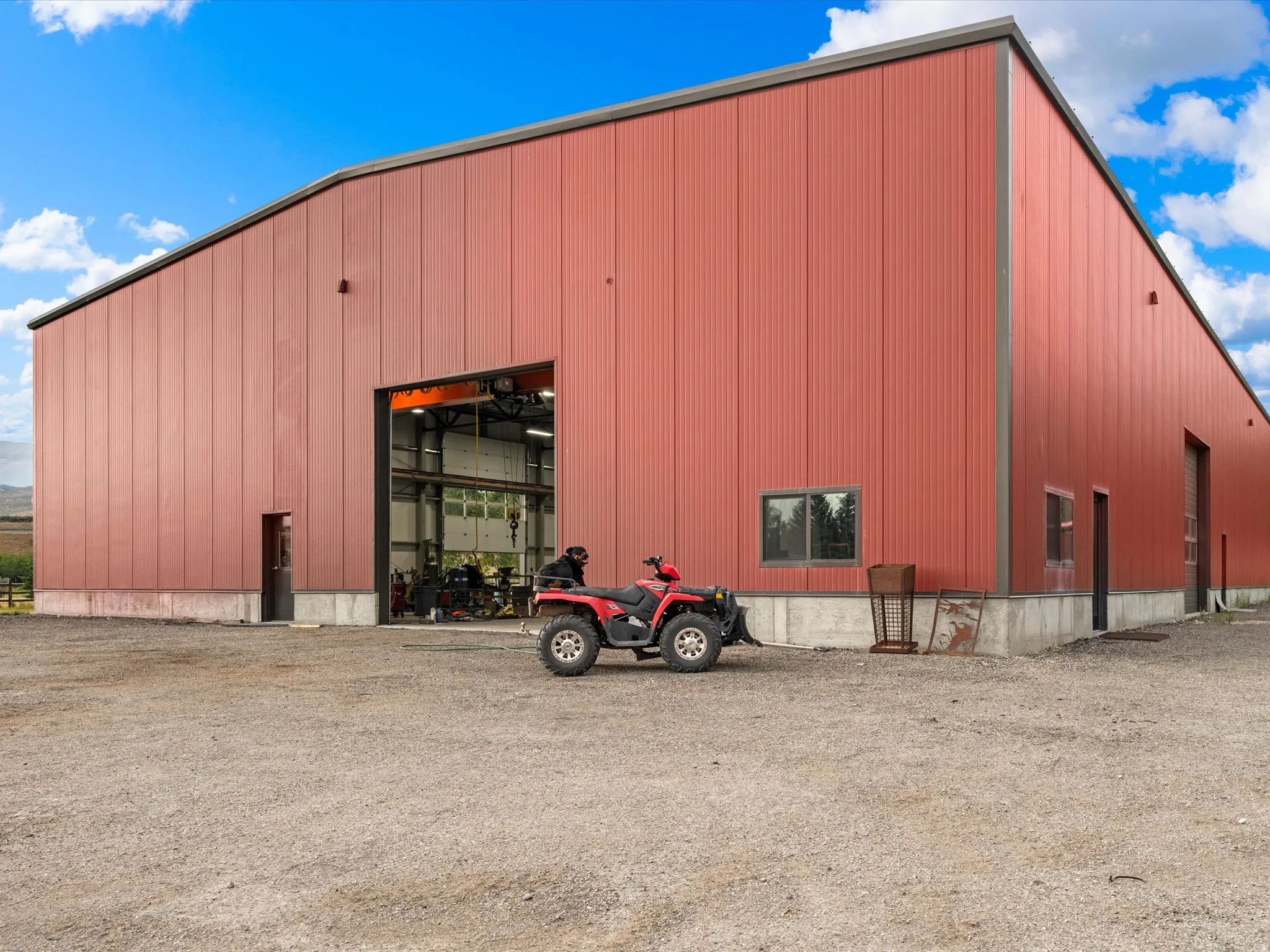 Large industrial building featuring red corrugated metal siding and a dark trim
