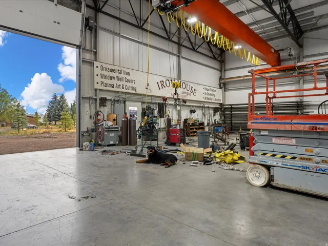 Industrial-style interior featuring high ceilings, exposed structural beams, and a large overhead crane system