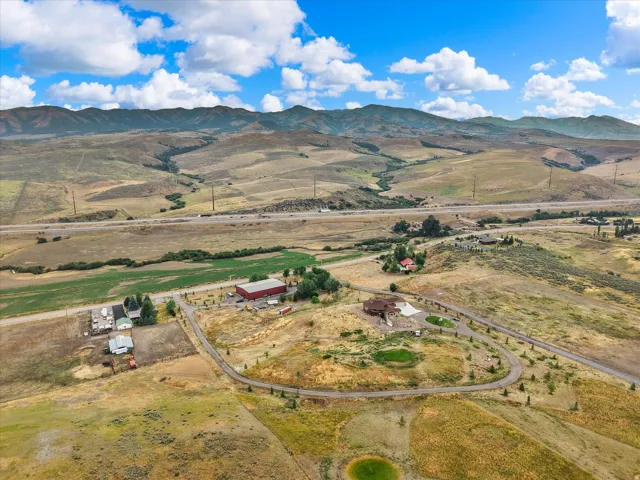 Expansive rural property featuring a large residence, a separate red outbuilding, and a winding private driveway
