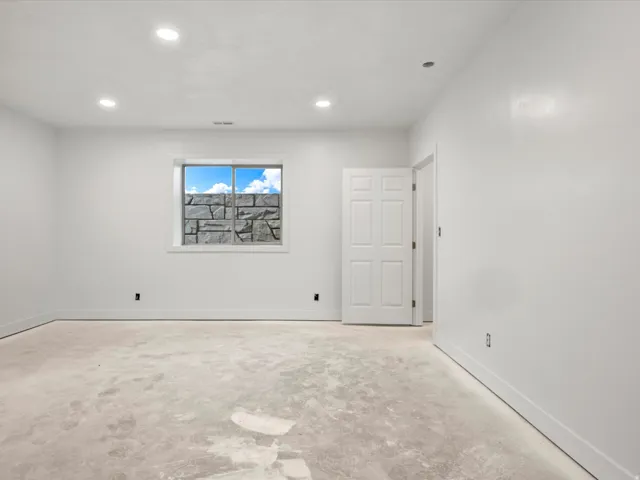 Spacious room with a window featuring a stone facade