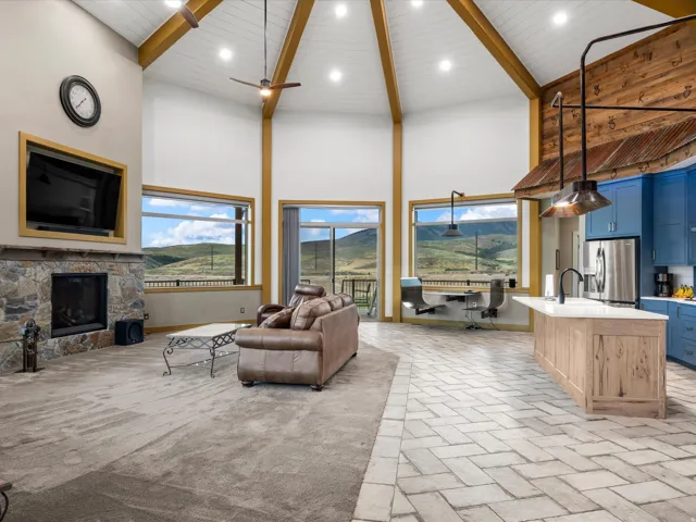 Vaulted ceiling with exposed wood beams, recessed lighting, and ceiling fans