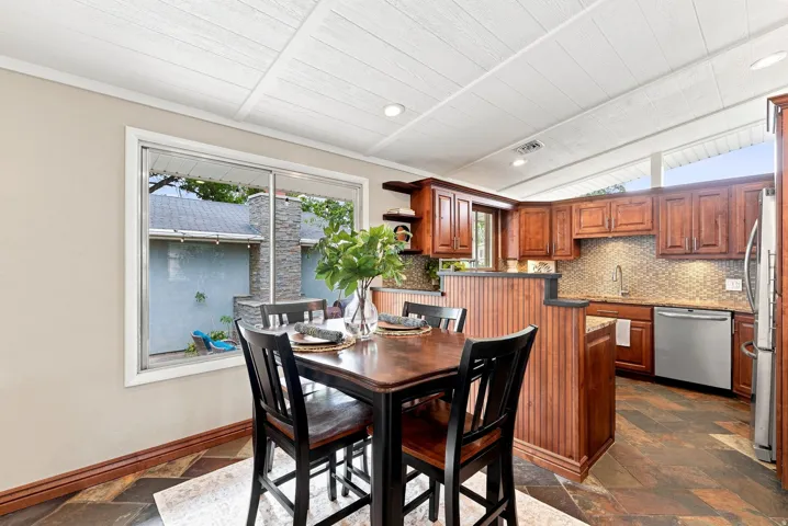 Dining area featuring a wood-finish table with four chairs, set against a neutral wall