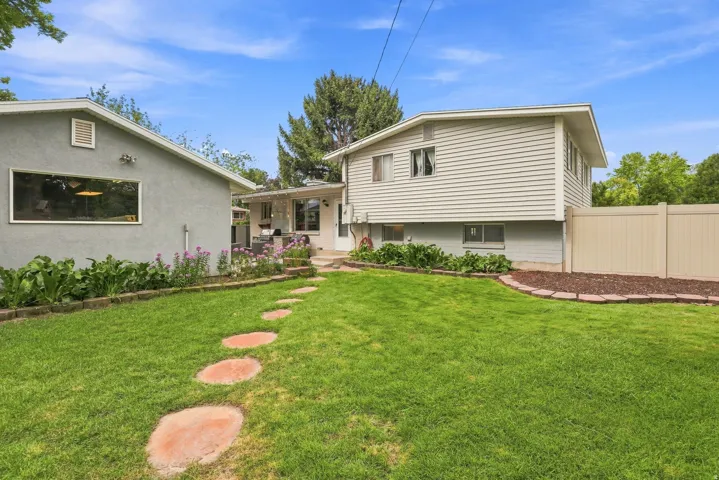 Expansive green lawn with stepping stones leading to a paved patio area