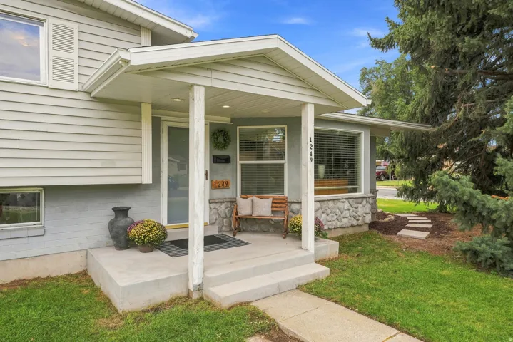 Front exterior with light gray siding and a stone facade foundation