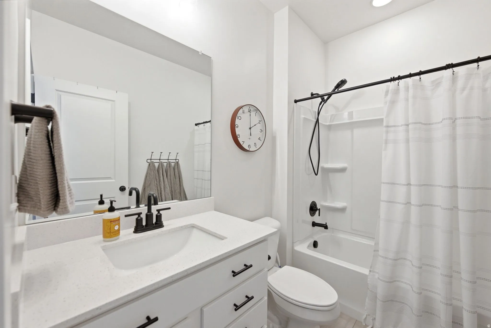 White vanity with integrated sink and dark hardware