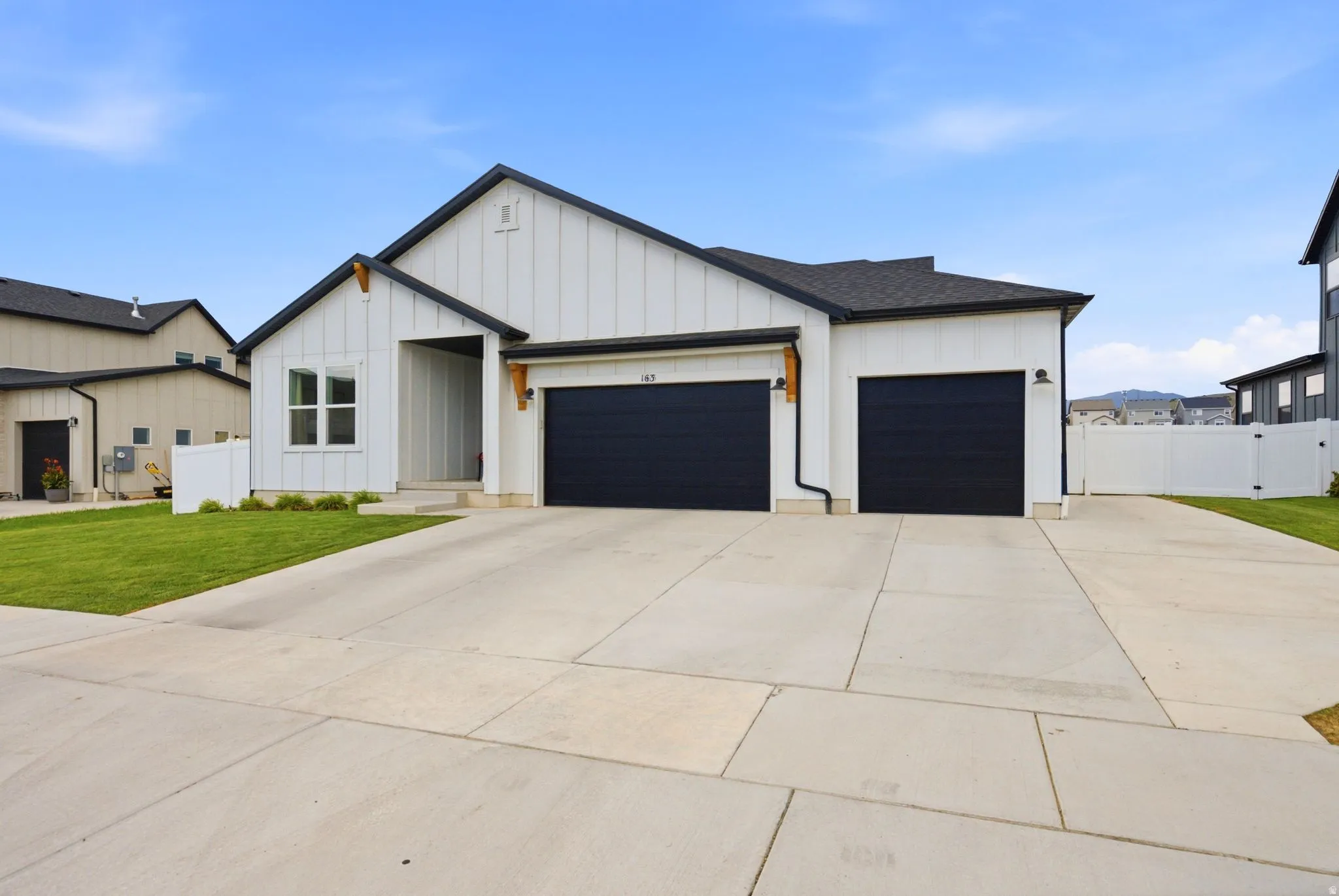 Modern farmhouse-style residence with a contrasting black roof and white board-and-batten siding
