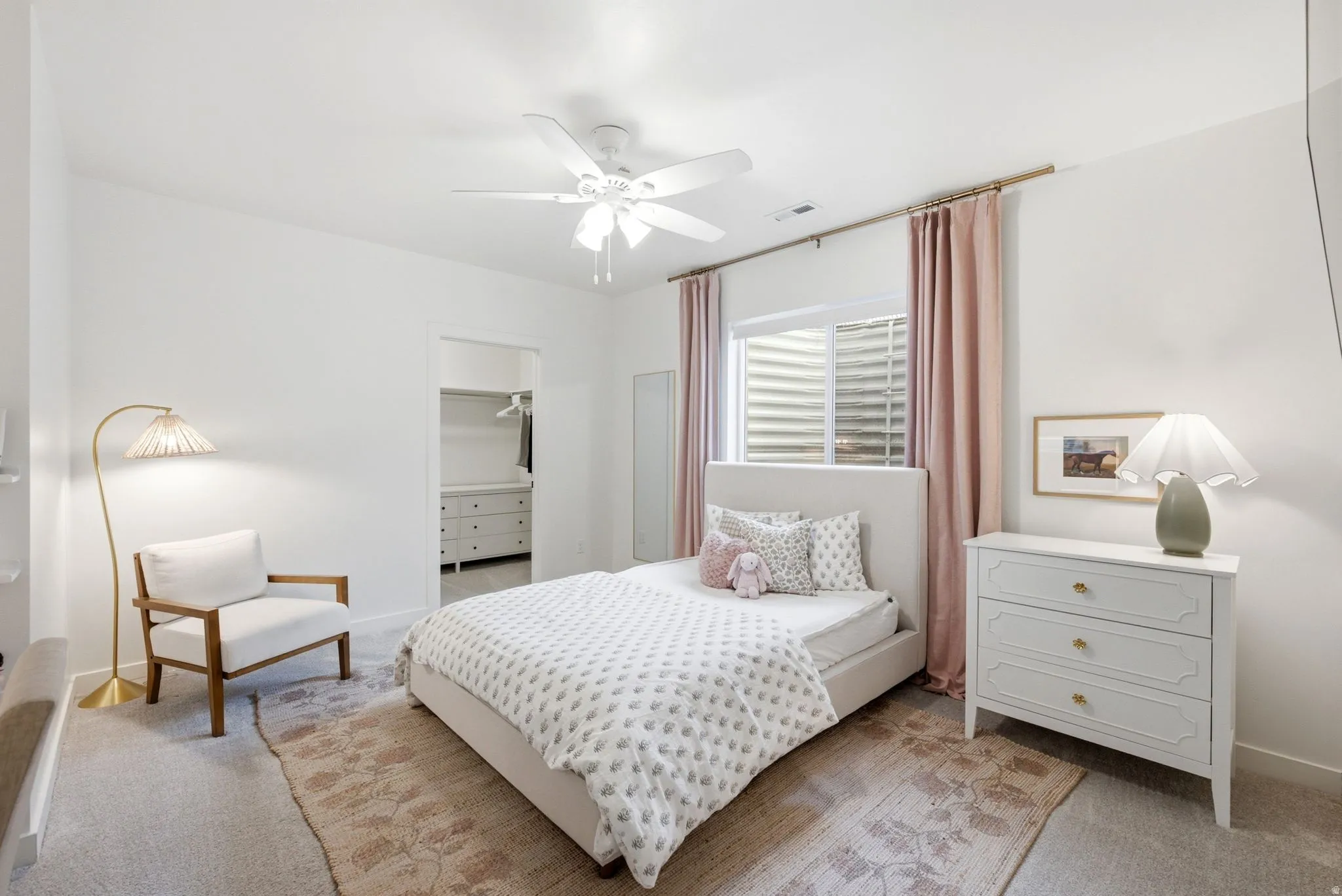 Bedroom featuring light-toned carpeting with a decorative area rug