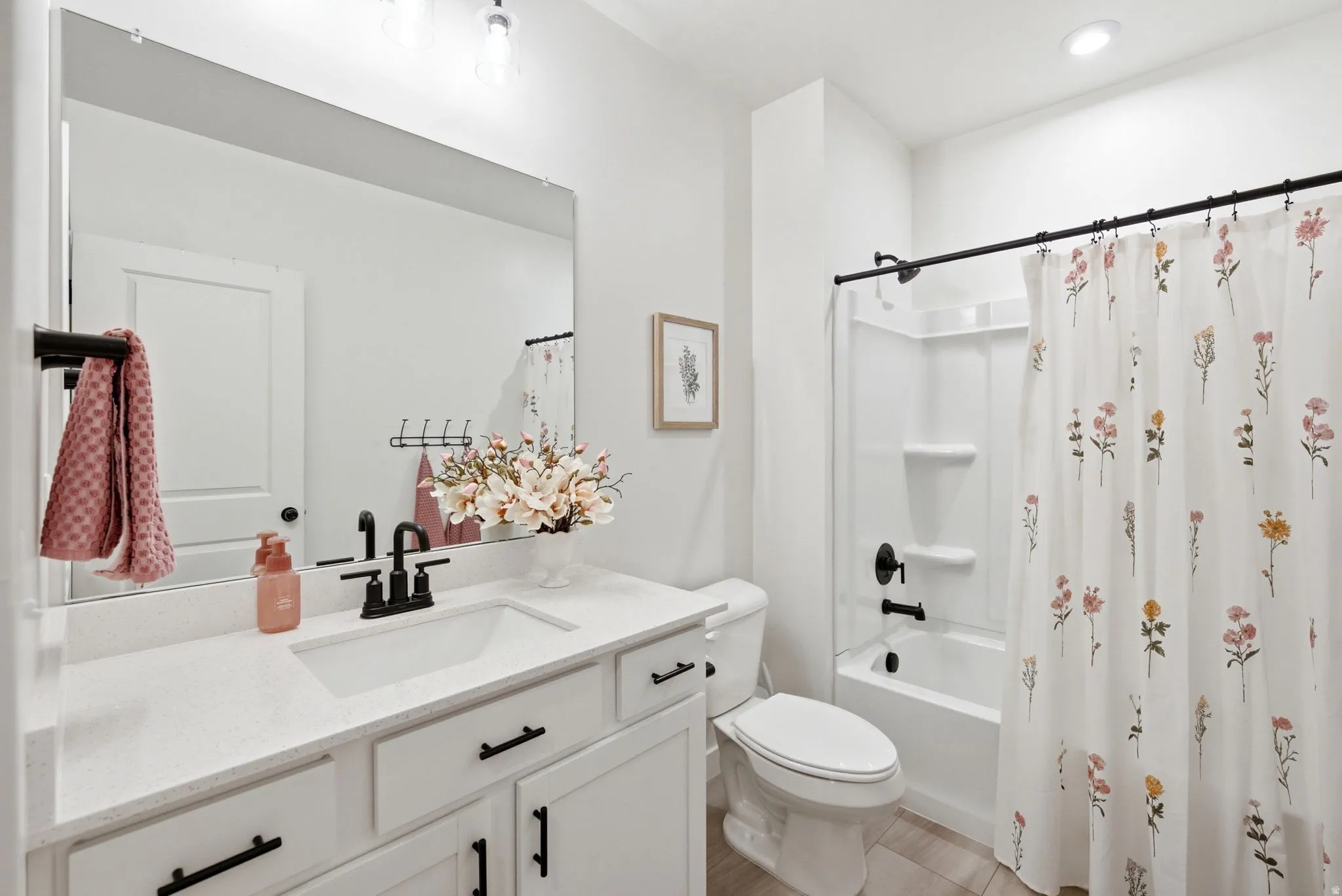 Bathroom featuring a white vanity with a rectangular undermount sink, quartz countertop, and black fixtures