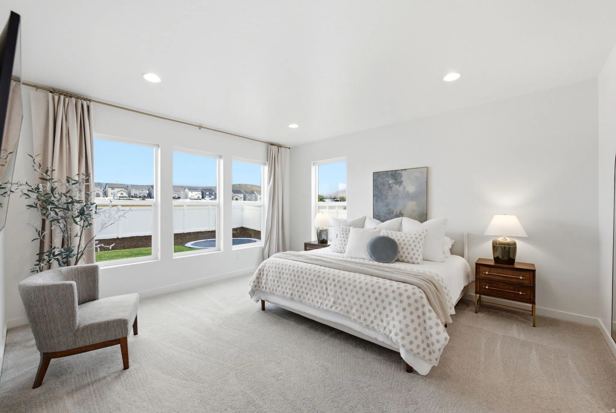 Spacious bedroom with light gray carpet and white walls