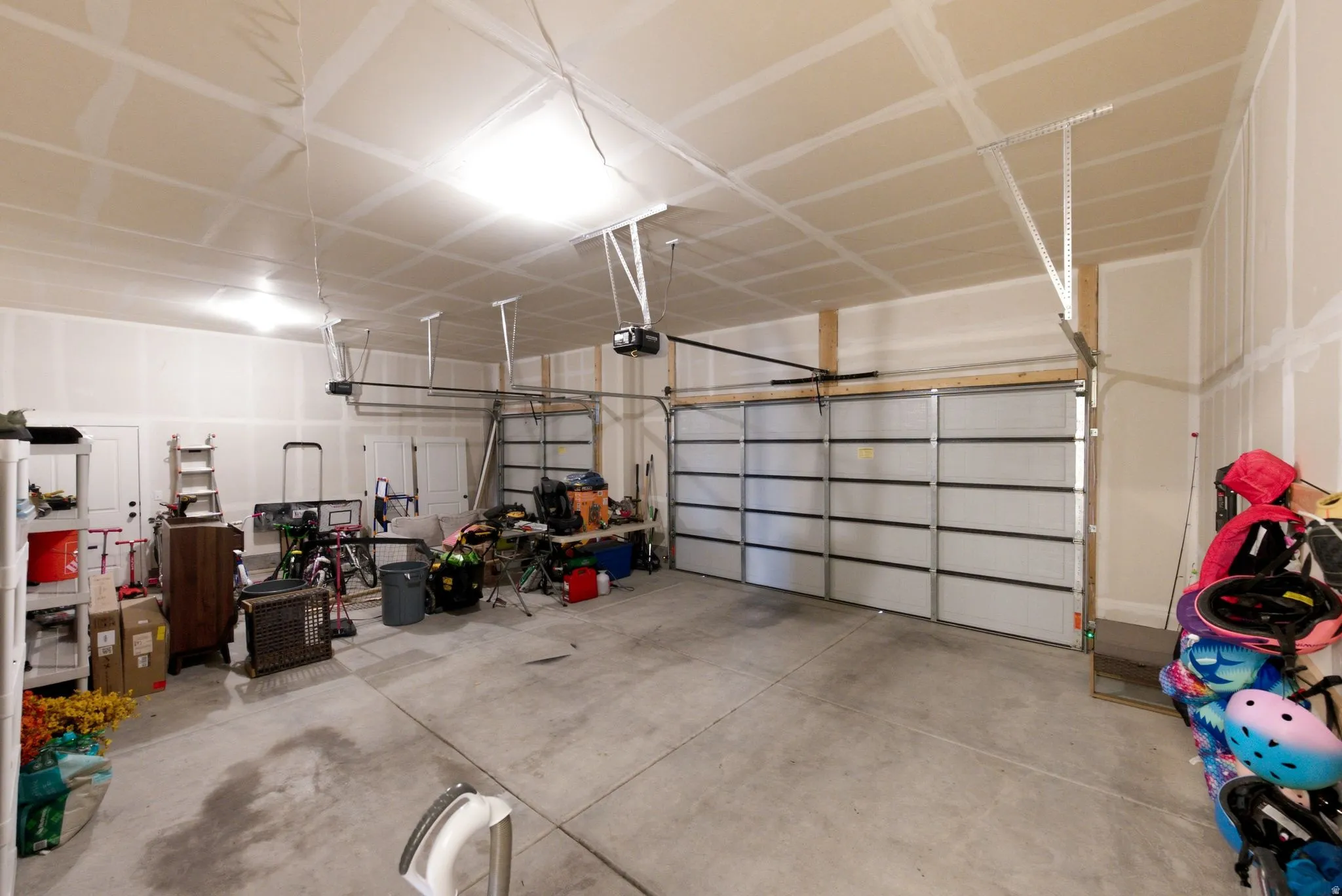Spacious two-car garage with concrete flooring and exposed ceiling rafters
