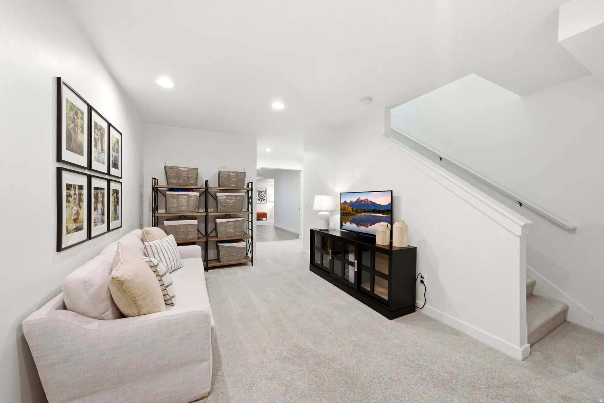 Open concept living area featuring light gray carpeting and white walls