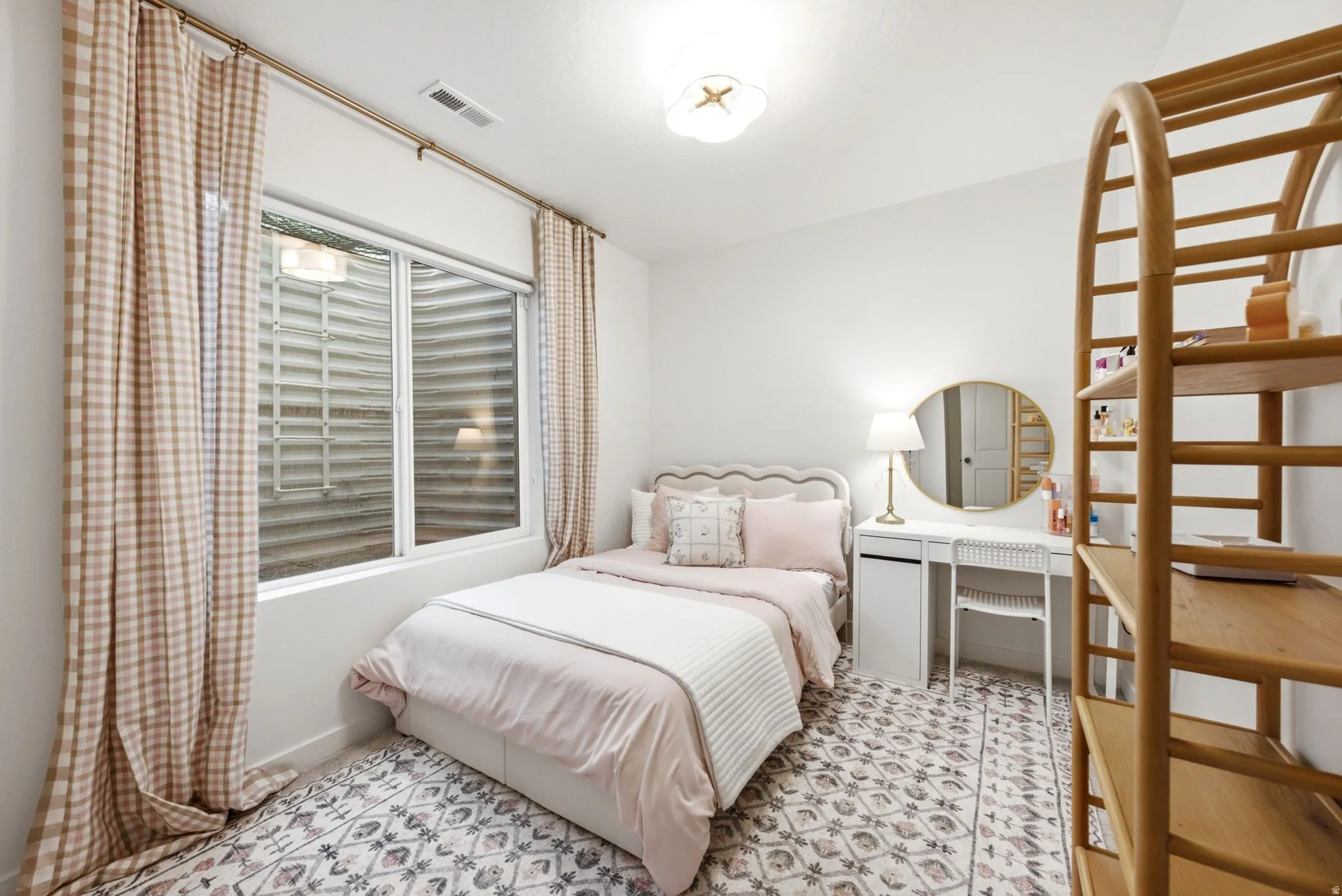 Room featuring a patterned area rug, a window with a window well, and a ceiling-mounted light fixture