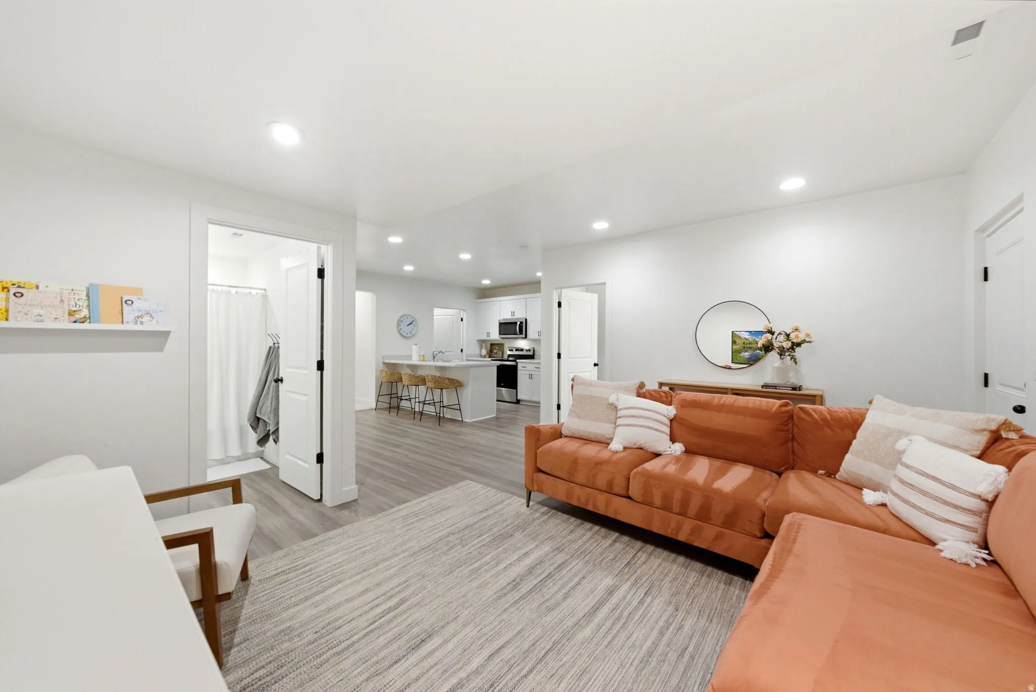 Open-concept living space featuring wood-finish flooring, recessed lighting, and white walls