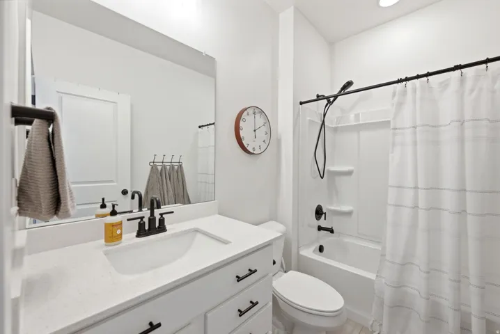White vanity with integrated sink and dark hardware
