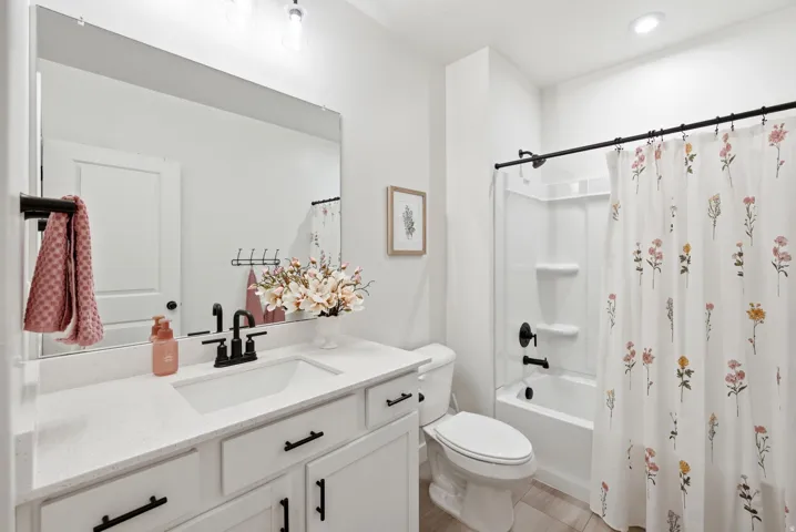 Bathroom featuring a white vanity with a rectangular undermount sink, quartz countertop, and black fixtures