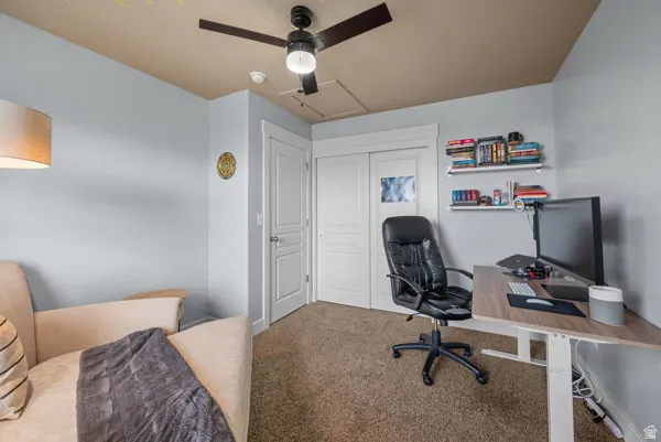 Carpeted room featuring a ceiling fan, two-tone painted walls, a built-in closet with sliding doors, and open shelving