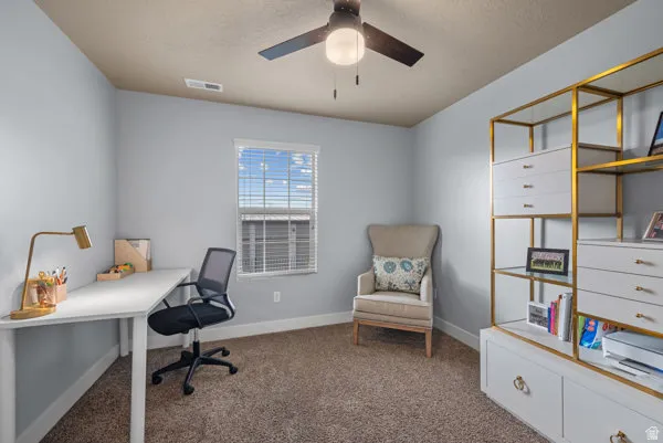 Room featuring light-colored walls, brown carpet, and a ceiling fan with integrated lighting