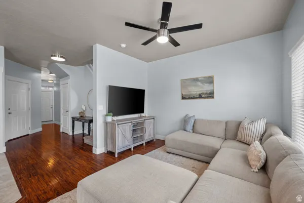 Open-concept living area with wood-finish flooring, light blue wall tones, and white trim